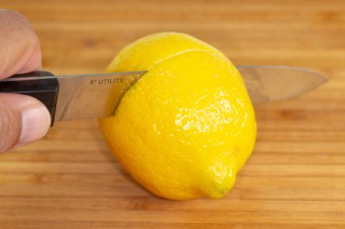 Mutfak masasının üzerinde bir kesme tahtası üzerinde ikiye dilimlenmiş limon