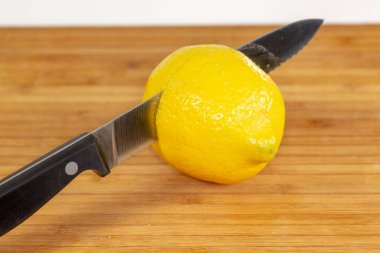 Mutfak masasının üzerinde bir kesme tahtası üzerinde ikiye dilimlenmiş limon
