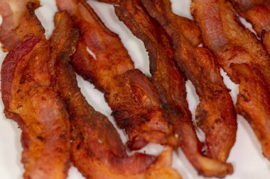 Beyaz tabakta yemiş olmak için bekleyen mutfak masasında kahvaltıda gevrek domuz pastırması dilim