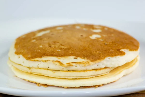 Uma Pilha Panquecas Douradas Prato Branco Sentado Uma Mesa Cozinha — Fotografia de Stock