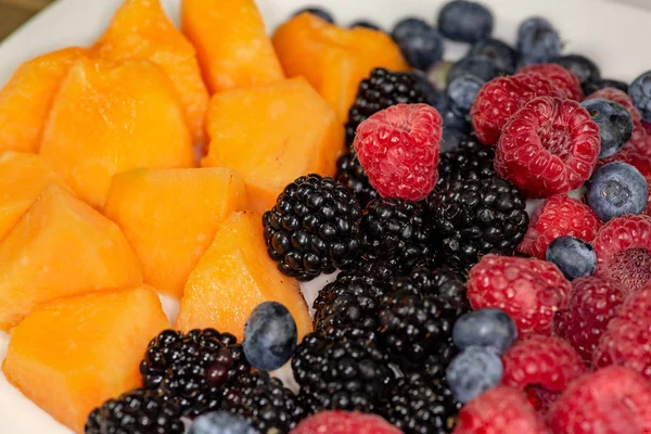 Une Assiette Cantaloup Bleuets Framboises Mûres Sur Une Assiette Blanche — Photo