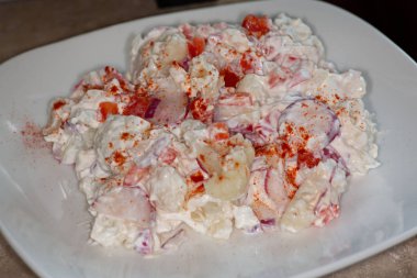 Karnabahar düşük carb ve bu Keto diyet için iyi bir patates salata yerine şut. Karnabahar, turp, tatlı soğan ve kırmızı biber kırmızı biber serpin yapılan.