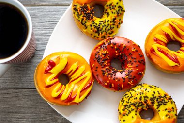 Cadılar Bayramı ve sonbahar sıcak kahve boru ile mutfak masası günü kahvaltıda sunulan lezzetli renkli donut renkli.