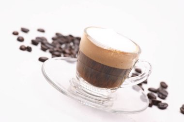 Kahve çekirdekleri ile beyaz bir arka plan üzerine açık bir bardak sıcak Cappuccino coffy.