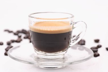 Sıcak siyah kahve kahve çekirdekleri ile beyaz bir arka plan üzerine açık bir cam.
