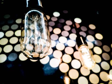 Turuncu tungsten ampul etrafında, aydınlatma, binada çok renkli elektrik lambaları, yumuşak focus.high kontrast biçimi ile siyah demir çit ile bina iç asılı.