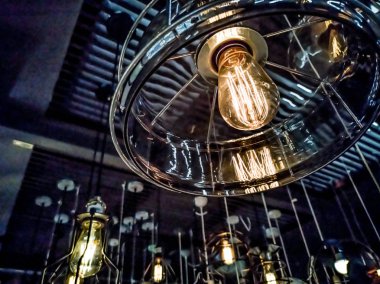 Turuncu tungsten ampul etrafında, aydınlatma, binada çok renkli elektrik lambaları, yumuşak focus.high kontrast biçimi ile siyah demir çit ile bina iç asılı.