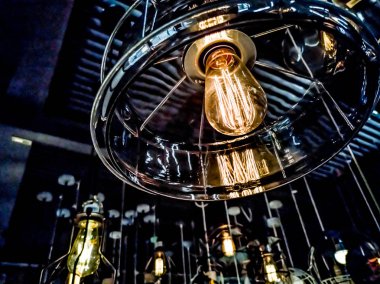 Turuncu tungsten ampul etrafında, aydınlatma, binada çok renkli elektrik lambaları, yumuşak focus.high kontrast biçimi ile siyah demir çit ile bina iç asılı.