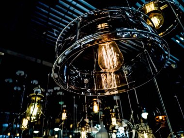 Turuncu tungsten ampul etrafında, aydınlatma, binada çok renkli elektrik lambaları, yumuşak focus.high kontrast biçimi ile siyah demir çit ile bina iç asılı.