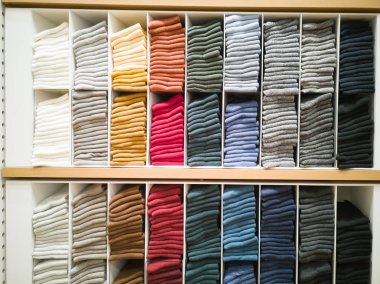 Pamuk T-shirt showroom, renkli elbise dolabında, katlanmış düzgünce katlanmış renkli elbise düzgünce giyinmiş, raflar ve büyük mağazalarda, bir satır renkli gömlek çok renkli giysiler.