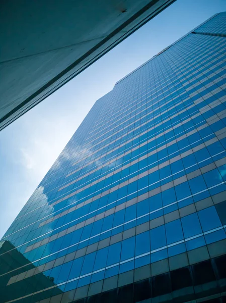 Mirror reflection of tall buildings.Shadow reflects the white clouds and the blue skies of glass of tall buildings.