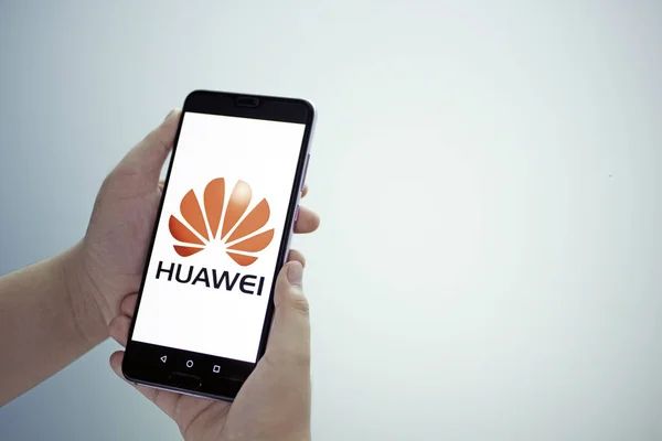 Bangkok, Tayland - 23 Mayıs 2019: Huawei telefonları kızların elinde, Huawei'nin güvenlik sorunları, iş krizleri, yeşil arka planda Huawei logo ekranı ile ilgilenilir.