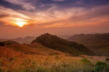 Akşam dağların güzel manzara, güneş düşüyor. Doi Samer-Dao, Nan, Tayland'da kışın güneş ışığı ve sis