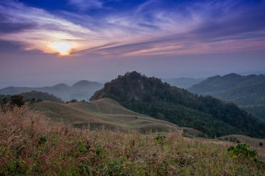 Akşam dağların güzel manzara, güneş düşüyor. Doi Samer-Dao, Nan, Tayland'da kışın güneş ışığı ve sis