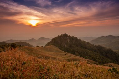 Akşam dağların güzel manzara, güneş düşüyor. Doi Samer-Dao, Nan, Tayland'da kışın güneş ışığı ve sis