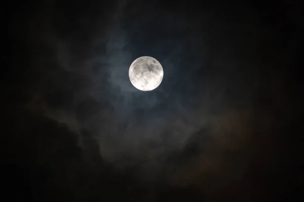 ดวงจันทร์เต็มดวงในคืนที่มืดมิดส่องแสงบนท้องฟ้าในวันที่มีเมฆ . — ภาพถ่ายสต็อก