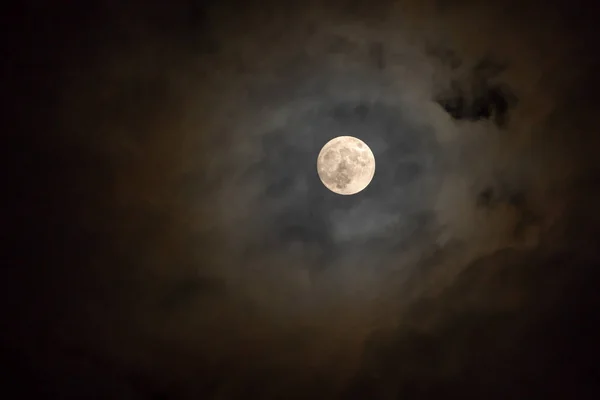 ดวงจันทร์เต็มดวงในคืนที่มืดมิดส่องแสงบนท้องฟ้าในวันที่มีเมฆ . — ภาพถ่ายสต็อก