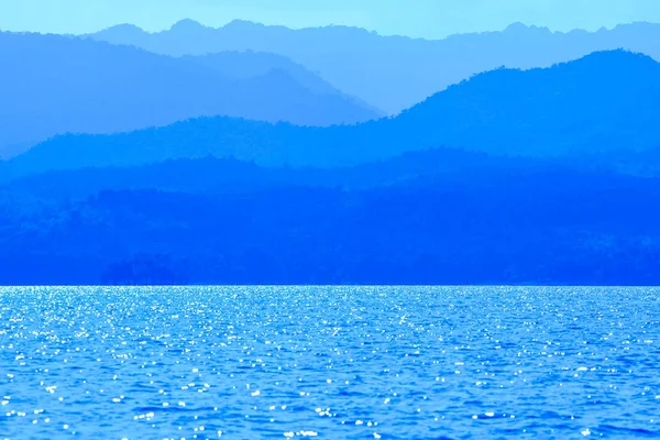 Luz azul reflejada desde la superficie del agua del lago con el —  Fotos de Stock