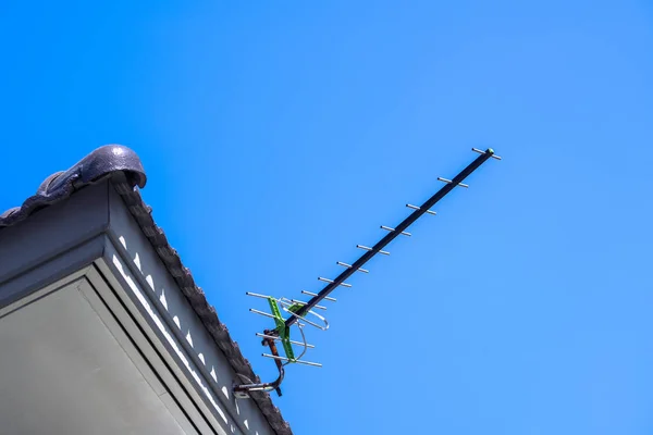 Antena de televisión con un cielo azul en el techo de la casa —  Fotos de Stock