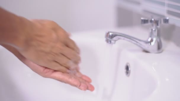 洗面所で蛇口の下の石鹸と水で手を洗う男コロナウイルスの感染を防ぐために家の中 Covid — ストック動画
