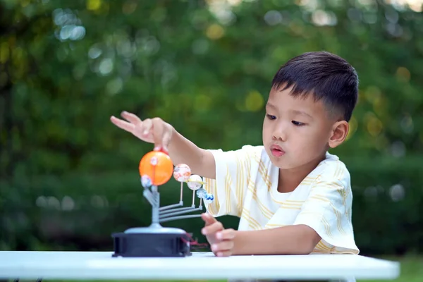 Asian boy Living Solar System Toys, Home Learning Equipment, during new normal change after coronavirus or post covid-19 outbreak pandemic situation