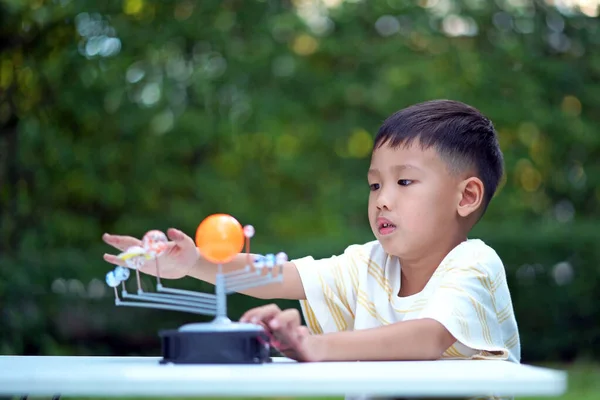 Asian boy Living Solar System Toys, Home Learning Equipment, during new normal change after coronavirus or post covid-19 outbreak pandemic situation