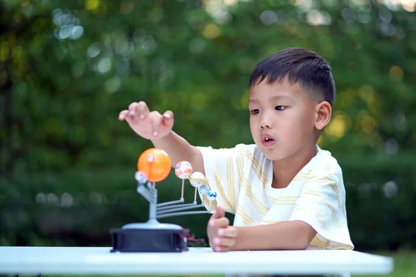 Asian boy Living Solar System Toys, Home Learning Equipment, during new normal change after coronavirus or post covid-19 outbreak pandemic situation