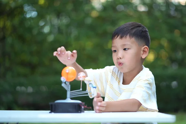 Asian boy Living Solar System Toys, Home Learning Equipment, Stay at home during new normal change after coronavirus or post covid-19 outbreak pandemic situation