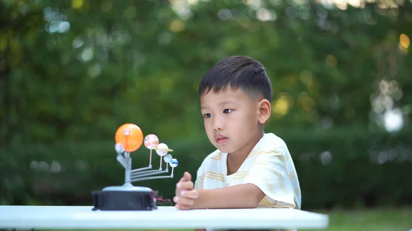 Asian boy Living Solar System Toys, Home Learning Equipment, Stay at home during new normal change after coronavirus or post covid-19 outbreak pandemic situation