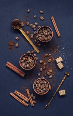 Kahve çekirdekleri seramik bardak ve çekilmiş kahve koyu arka plan üzerinde. Üstten görünüm