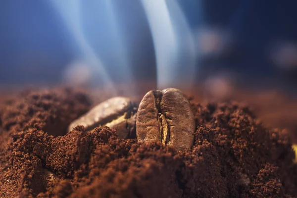 Ground coffee and grains macro shot. Smoke from freshly roasted coffee beans