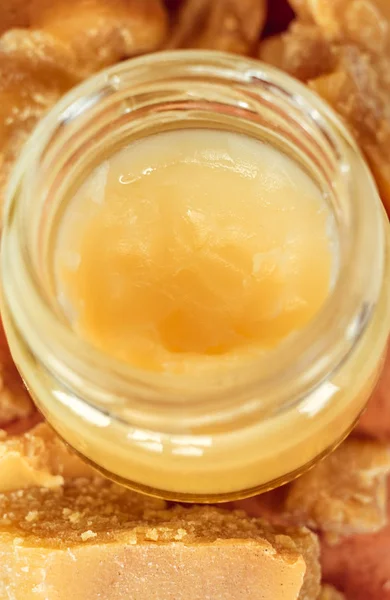 Hand cream or lip balm in a glass jar. Natural organic cosmetics with honey, wax