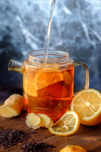 Ingredients of ginger tea, teapot with ginger and lemon tea, healthy and warm tea according to a simple recipe