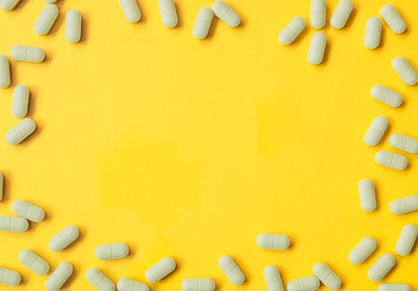 Kapsułki tabletki wzór na żółtym tle — Zdjęcie stockowe