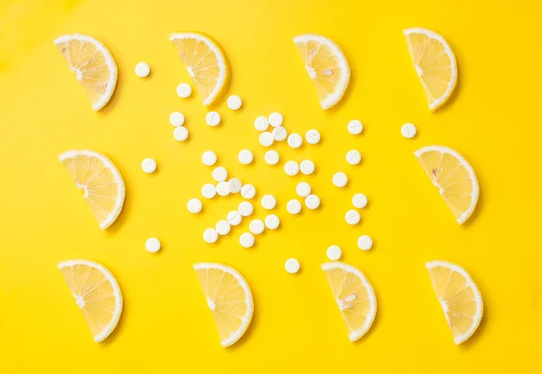 Vitamina C. Rebanadas de limón sobre un fondo brillante y píldoras de vitamina C. Maqueta de marca de productos de belleza. Vista superior . —  Fotos de Stock