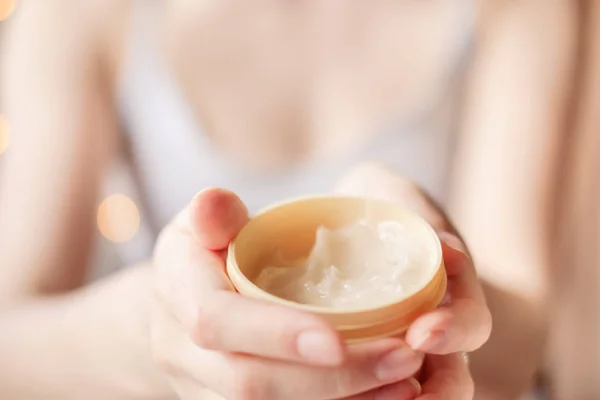 Hermosas manos de mujer arreglada con crema para el cuerpo y la piel sobre un fondo claro . — Foto de Stock