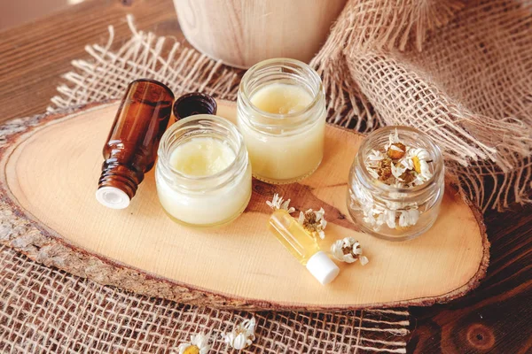 Crema de manos y bálsamo labial en un frasco de vidrio. Cosméticos orgánicos naturales con miel, cera y aceites . — Foto de Stock