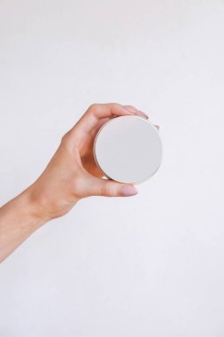 Güzel bakımlı kadın elleri, hafif bir arka planda vücut kremi ve cilt kremi.