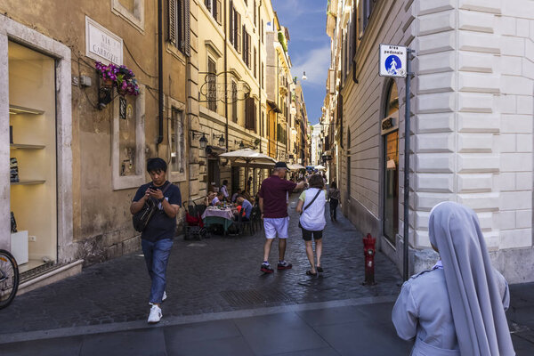 Рим / Италия - 26 августа 2018 года: Итальянская улица Via Delle Carrozze с туристами, уличными кафе и голосующей
