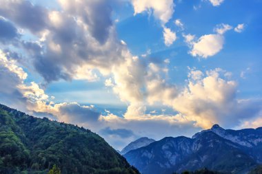 Güneş ışığı ve bulutların üzerinde bir ahşap ile Avusturya taç hill
