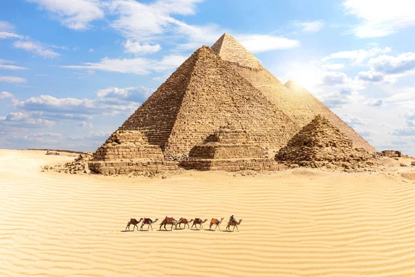 Die großen Pyramiden von Giza und ein Zug von Kamelen in der Wüste, — Stockfoto