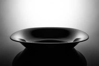 Boş siyah çorba tabağı, gölgelerde izole