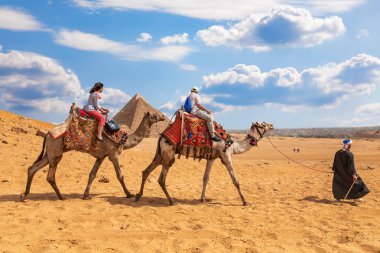 Giza Piramitleri yakınında deve sürme turistler
