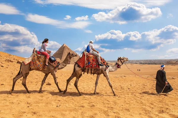 Turistas montando camellos cerca de las Pirámides de Giza —  Fotos de Stock