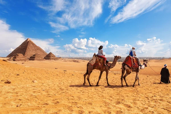 Turistler, develer, bedeviler ve Giza çölündeki Piramitler — Stok fotoğraf