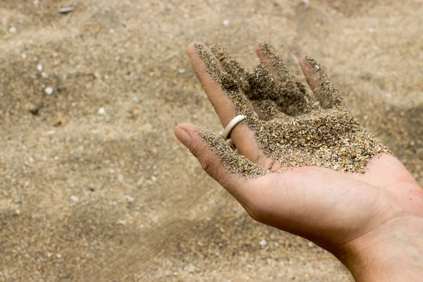 Sand running out from hand at the beach — Stock Photo, Image