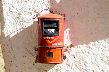 Beyaz duvarda asılı kırmızı Kızılderili posta kutusu. İletişim konsepti.