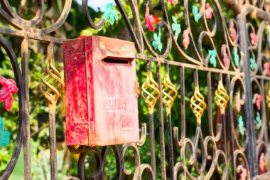 Kırmızı metal posta kutusunda bir güzel demir çit