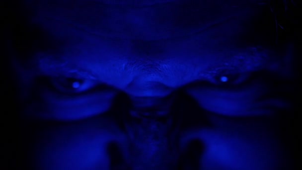 可怕的邪恶恐怖的眼睛在黑暗中照亮蓝色的光 — 图库视频影像