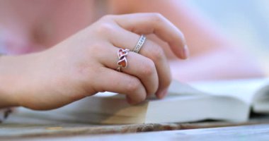 Okuma ve kağıt kapaklı kitap sayfaları çevirme